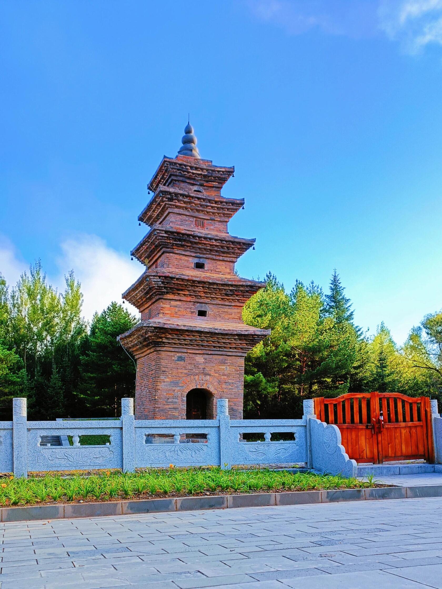 An ancient brick pagoda, Lingguang Tower, standing against a blue sky, reflecting historical depth.