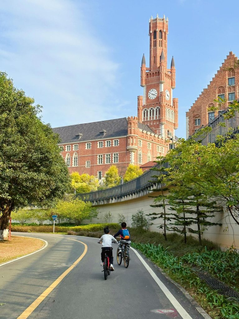 Children cycling on a quiet road, Gothic architecture in the background, a serene GBA Road Trip scene