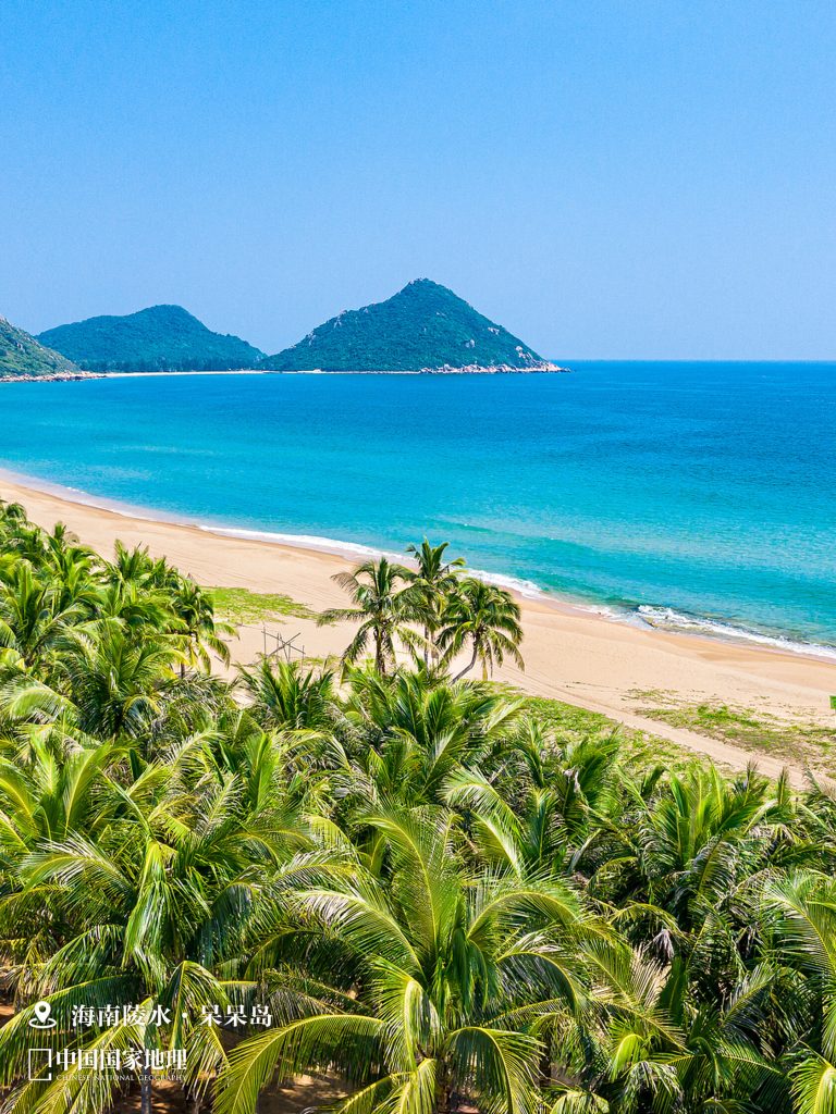 A pristine beach with clear blue waters and palm trees, highlighting the coastal diversity of China, contrasting with the inland Shanxi Taihang Exploration.