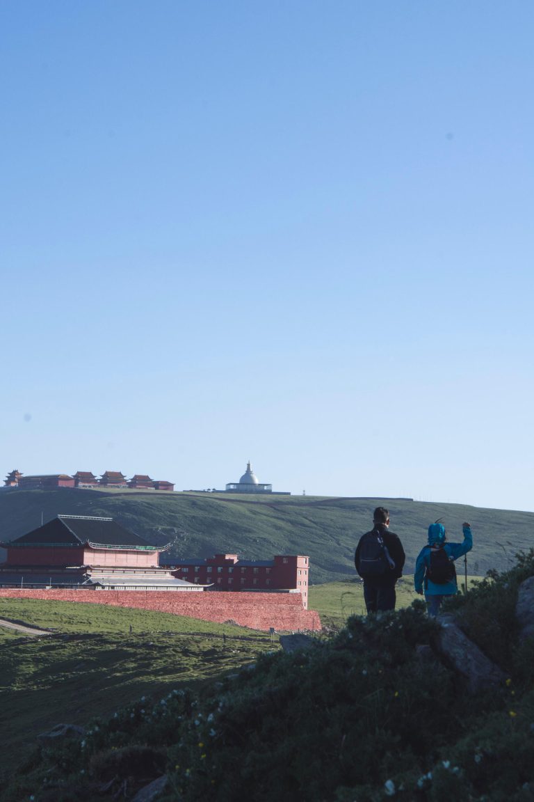 Scenic view of a mountainous area with distant structures, indicating a geological and cultural site during the Shanxi Taihang Exploration.