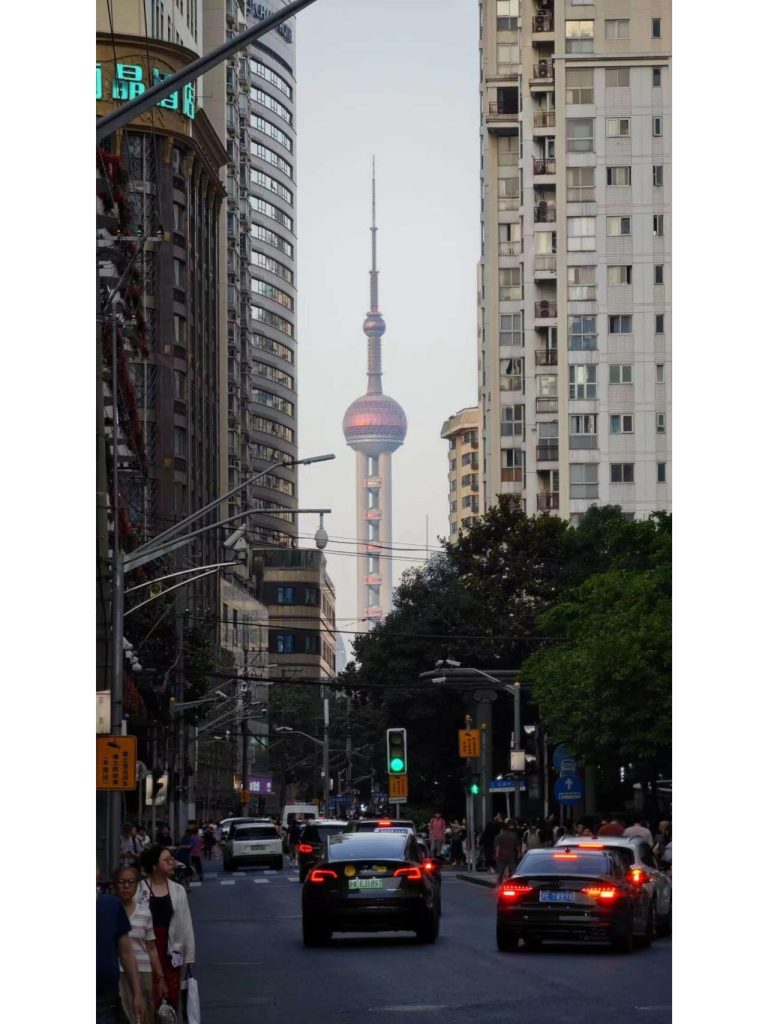 Shanghai city street at night with the Oriental Pearl Tower in the distance, a highlight of my Yangtze Delta Adventure.