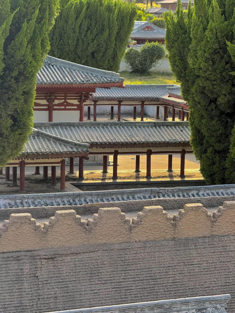 Ancient Chinese architecture with red pillars and grey roofs, a glimpse into the past of the Hexi Corridor Adventure.