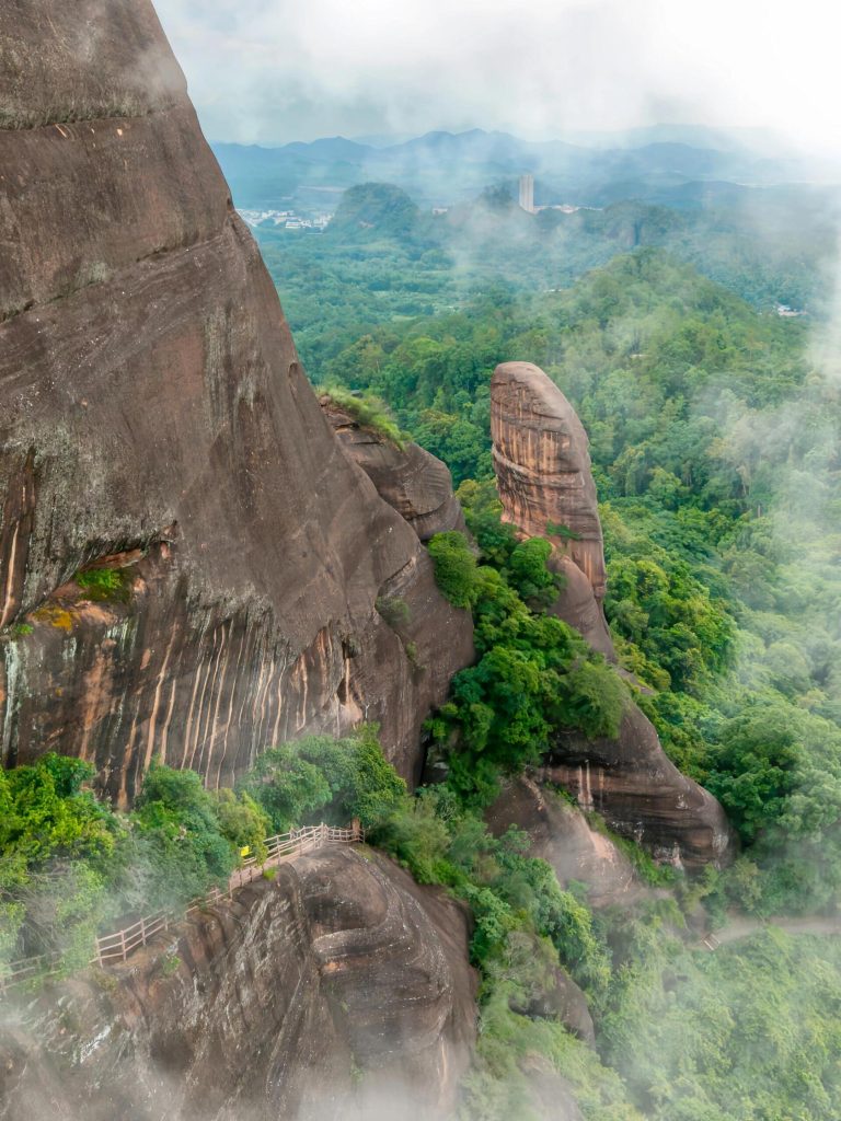 A wooden walkway winding through majestic karst peaks and lush greenery, highlighting the Karst Landscape Wonders.